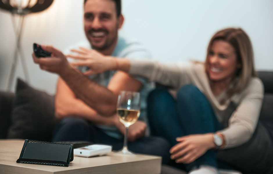 Couple fighting for control of the remote during their movie date night