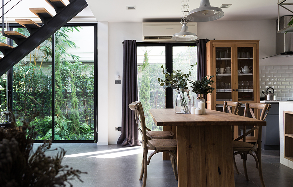 Kitchen interior with wood furniture, plants, and natural light