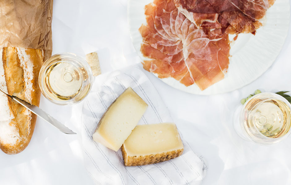 Overhead image of meat, cheese, and wine