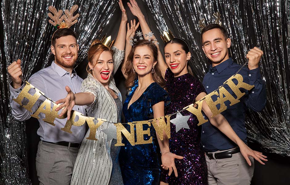 Guests posing in front of metallic fringe backdrop